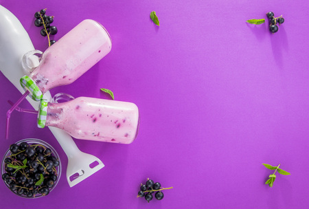 Fruity smoothie in glasses with black currant on purple background. Healthy eating. Organic food.の写真素材