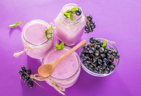 Fruity smoothie in glasses with black currant on purple background. Healthy eating. Organic food.の写真素材