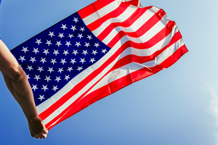 Man holding national USA flag. Celebrating Independence Day of America. July 4th