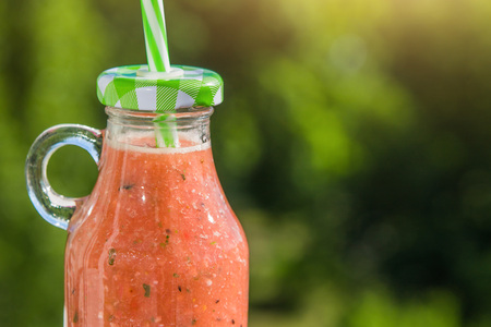 Bottle of fruity smoothie on green background outside. Healthy organic foodの写真素材