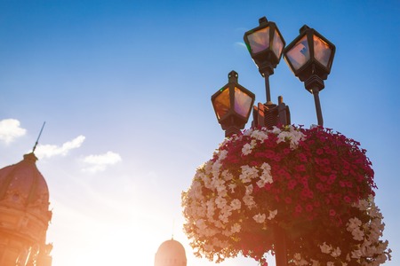 Architecture of Lviv streets on blue sky background at sunset. Lamp with flowersの写真素材