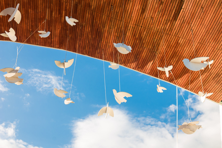 Sorochinskyi Fair decoration in Velyki Sorochyntsi. Hanging paper doves against blue sky as symbol of peace.の写真素材