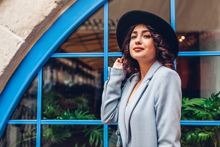 Beautiful young woman wearing stylish autumn outfit. Outdoor portrait of fashion model on city streetの写真素材