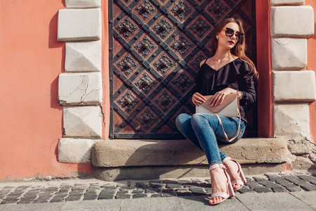 Outdoor portrait of beautiful stylish woman in glasses on street. Fashion model wearing summer clothing and accessoriesの写真素材