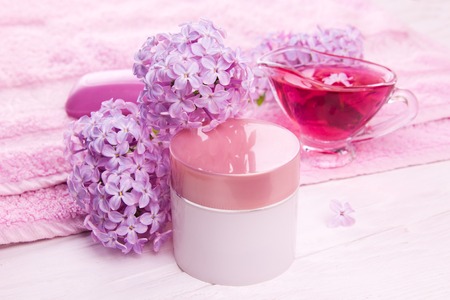 Spa essentials including with cream, pink towel, soap and oil with lilac. Natural cosmeticsの写真素材
