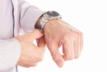 Man puts his watch on. Isolated on white. Male accessories. Stylish look. Closeup of handsの写真素材