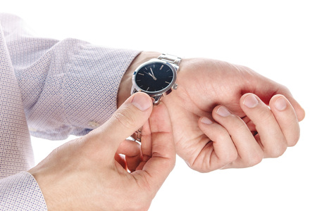 Man puts his watch on. Isolated on white. Male accessories. Stylish look. Closeup of handsの写真素材