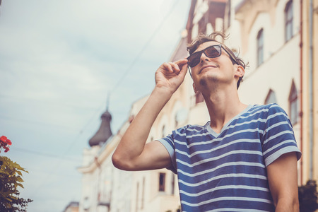 Happy young man tourist visiting places of interest in old cityの写真素材