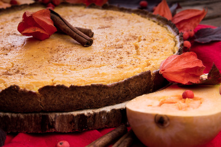 Pumpkin pie with berries and cinnamon. Autumn dessert on wooden table. Foodの写真素材