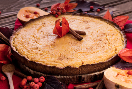 Pumpkin pie with berries and cinnamon. Autumn dessert on wooden table. Foodの写真素材