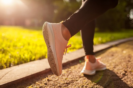 Closeup of sneakers. Young sportive woman running in summer park. Sportswoman jogging. Workout. Trainingの写真素材
