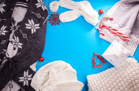 Winter female outfit. Set of clothes and accessories on blue background. Knitted clothing. Copy spaceの写真素材