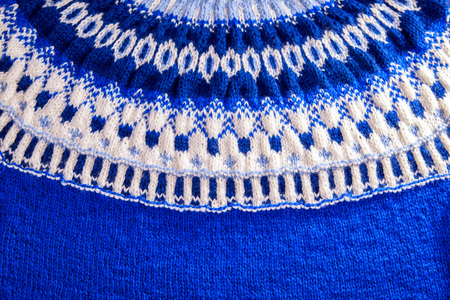 Ornament of a blue and white icelandic sweater. Knitted winter clothes.の写真素材