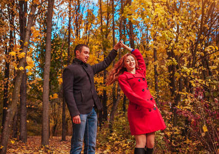 Young couple in love dances in autumn forest among colorful treesの写真素材
