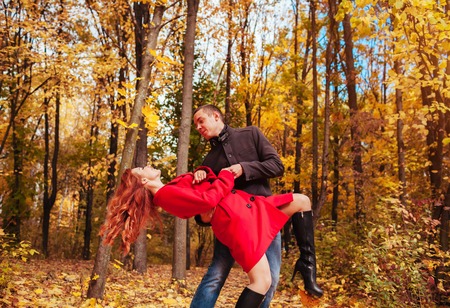 Young couple in love dances in autumn forest among colorful treesの写真素材