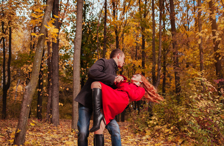 Young couple in love dances in autumn forest among colorful treesの写真素材