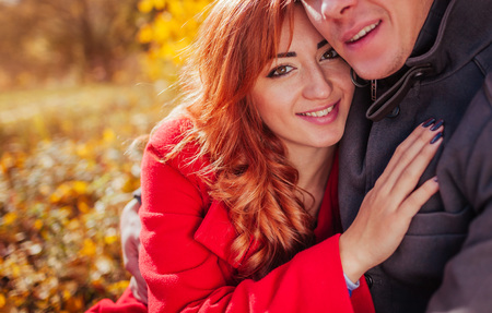 Young couple in love hugs in autumn forest among colorful trees. Happy people smilingの写真素材