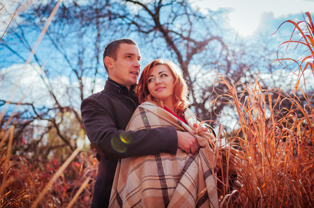 Young couple in love hugs in autumn forest among high grass. Happy people smilingの写真素材