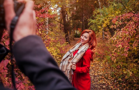 Man takes a picture of his girlfriend dancing in autumn forestの写真素材