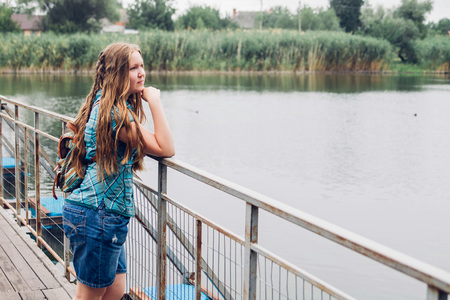 Teenager traveler girl walks across the bridge before rainの写真素材