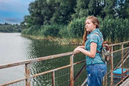 Teenager traveler girl walks across the bridge before rainの写真素材