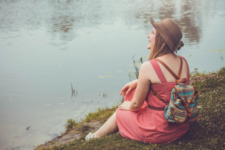 Teenager traveler girl sits beside the river before rainの写真素材