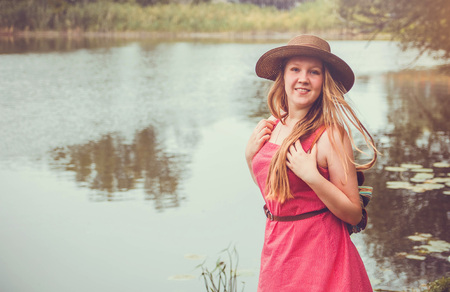 Teenager traveler girl walks beside the river before rainの写真素材