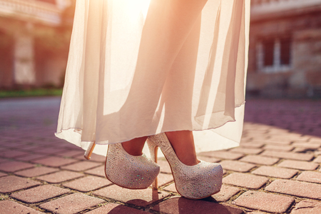 Stylish woman wearing high heeled shoes and white dress outdoors. Beauty fashion. Footwearの写真素材