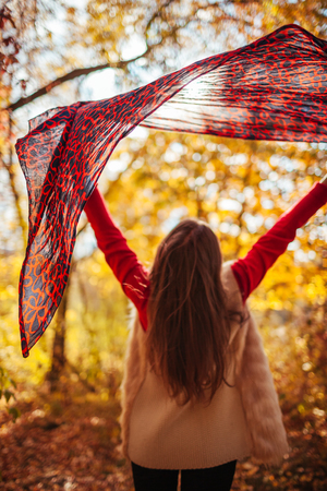 Young woman running with a scarf in autumn forestの写真素材