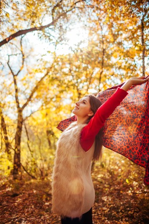 Young woman running with a scarf in autumn forestの写真素材