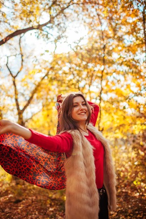 Young woman running with a scarf in autumn forestの写真素材