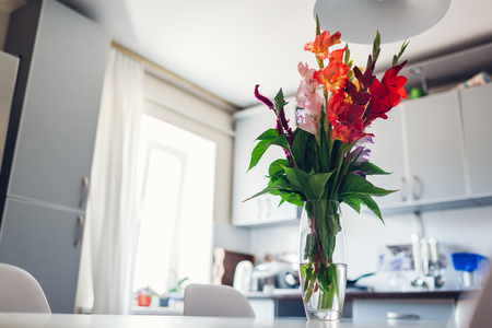 Modern kitchen design. Interior of white and silver kitchen decorated with flowers. New cozy apartmentの写真素材