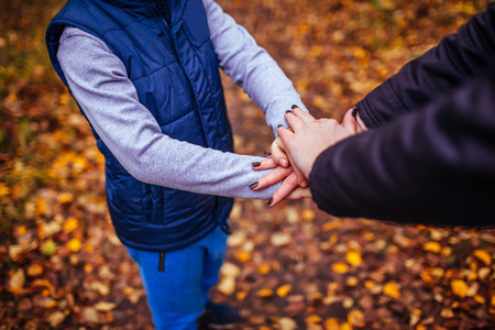 Hands of a little boy and his sister together in autumn forest. One sportive teamの写真素材