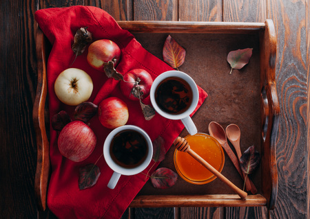 Hot tea with apples and honey on a wooden tray. Autumn harvestの写真素材