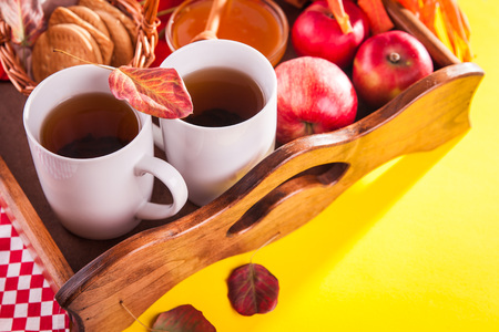 Hot tea with apples and honey on a wooden tray. Autumn harvestの写真素材
