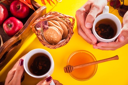 Hot tea with apples and honey on a wooden tray. Autumn harvestの写真素材
