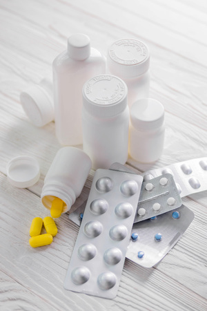 Set of pills in white bottles on wooden background. Medicine. Health careの写真素材