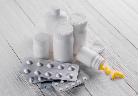 Set of pills in white bottles on wooden background. Medicine. Health careの写真素材