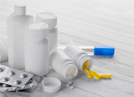 Set of pills in white bottles on wooden background. Medicine. Health careの写真素材