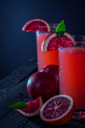 Homemade blood orange juice on black background. Refreshing summer cocktailの写真素材