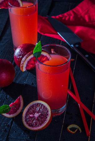 Homemade blood orange juice on black background. Refreshing summer cocktailの写真素材