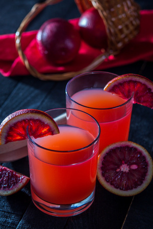 Homemade blood orange juice on black background. Refreshing summer cocktailの写真素材