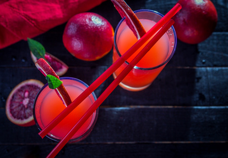Homemade blood orange juice on black background. Refreshing summer cocktailの写真素材