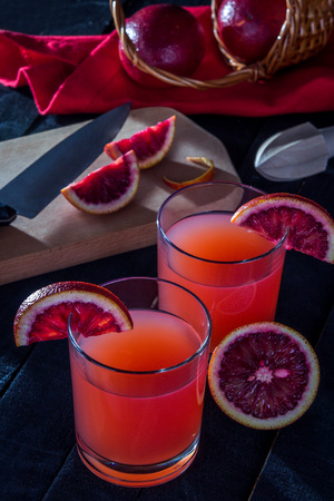 Homemade blood orange juice on black background. Refreshing summer cocktailの写真素材
