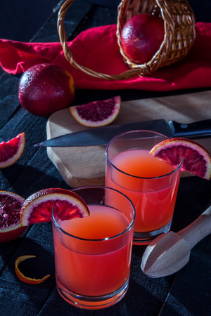 Homemade blood orange juice on black background. Refreshing summer cocktailの写真素材