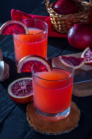 Homemade blood orange juice on black background. Refreshing summer cocktailの写真素材