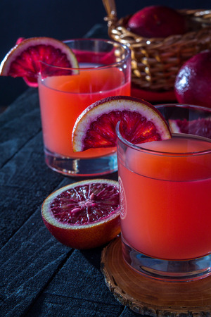 Homemade blood orange juice on black background. Refreshing summer cocktailの写真素材