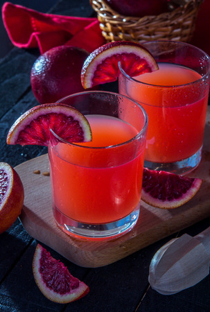 Homemade blood orange juice on black background. Refreshing summer cocktailの写真素材