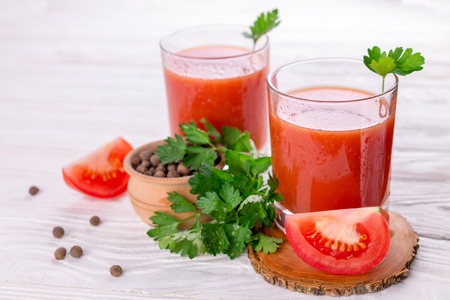 Tomato juice in glasses on white wooden background. Bloody Maryの写真素材
