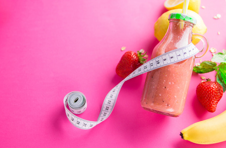 Fruity smoothie with ingredients on pink background. Healthy eating concept.の写真素材